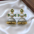 Pair of gold and silver earrings with green accents on a white fabric background