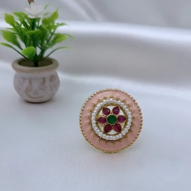 Decorative ring with pink and gold design on a white background