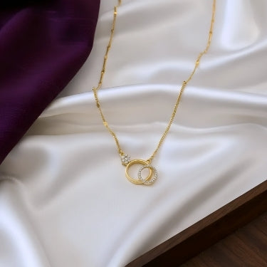 Gold necklace with a circular pendant on a white fabric background