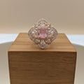 Elegant ring with a pink gemstone on a wooden box