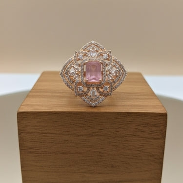Elegant ring with a pink gemstone on a wooden box