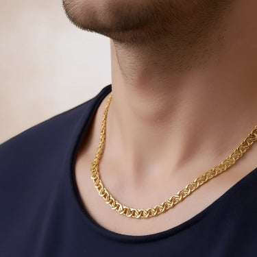 Gold chain necklace worn by a person on a neutral background