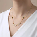 Gold necklace with black beads on a white background
