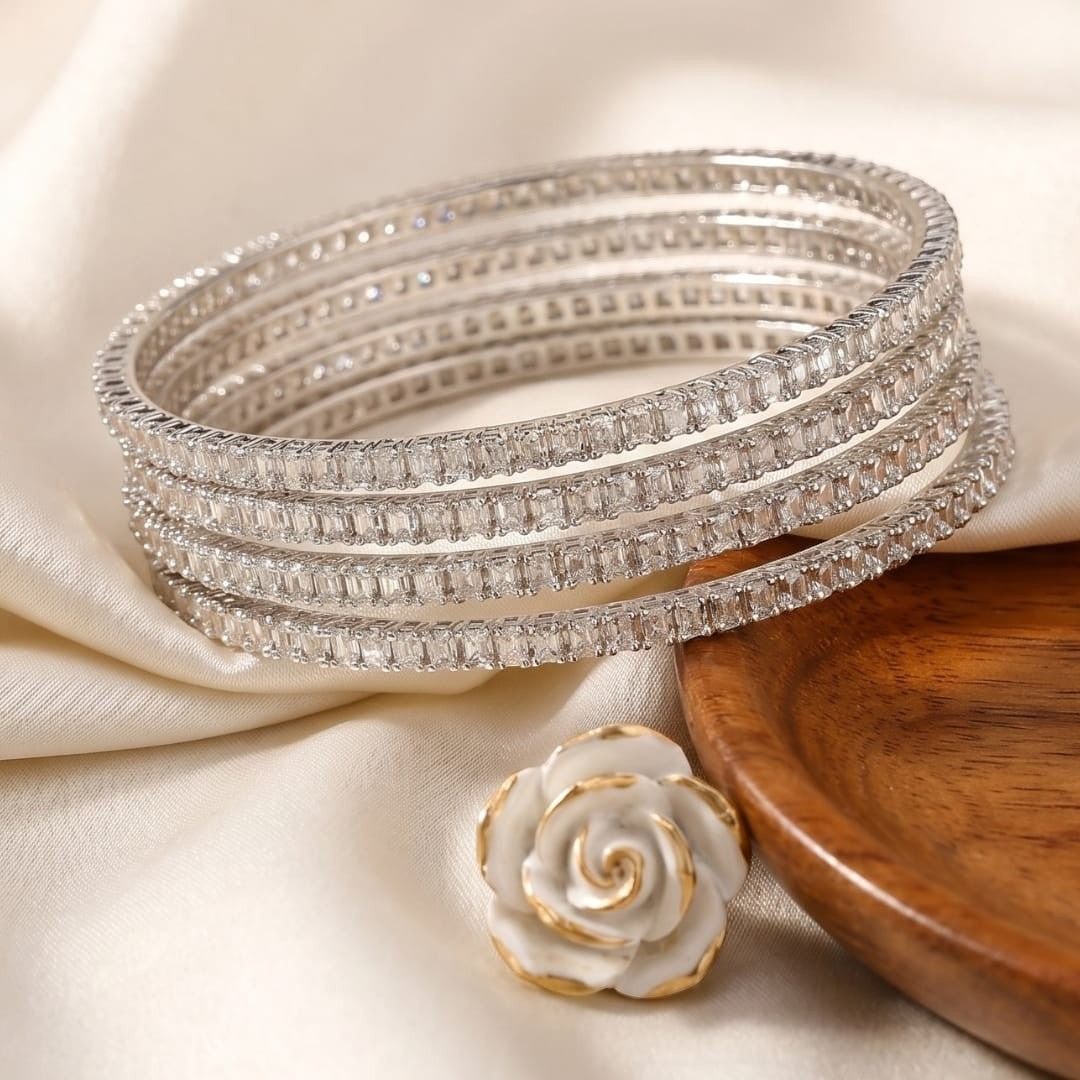 Shinayra by Nakhrali Creation set of 4 silver bangles with emerald-cut zircon stones, rhodium-plated finish.
