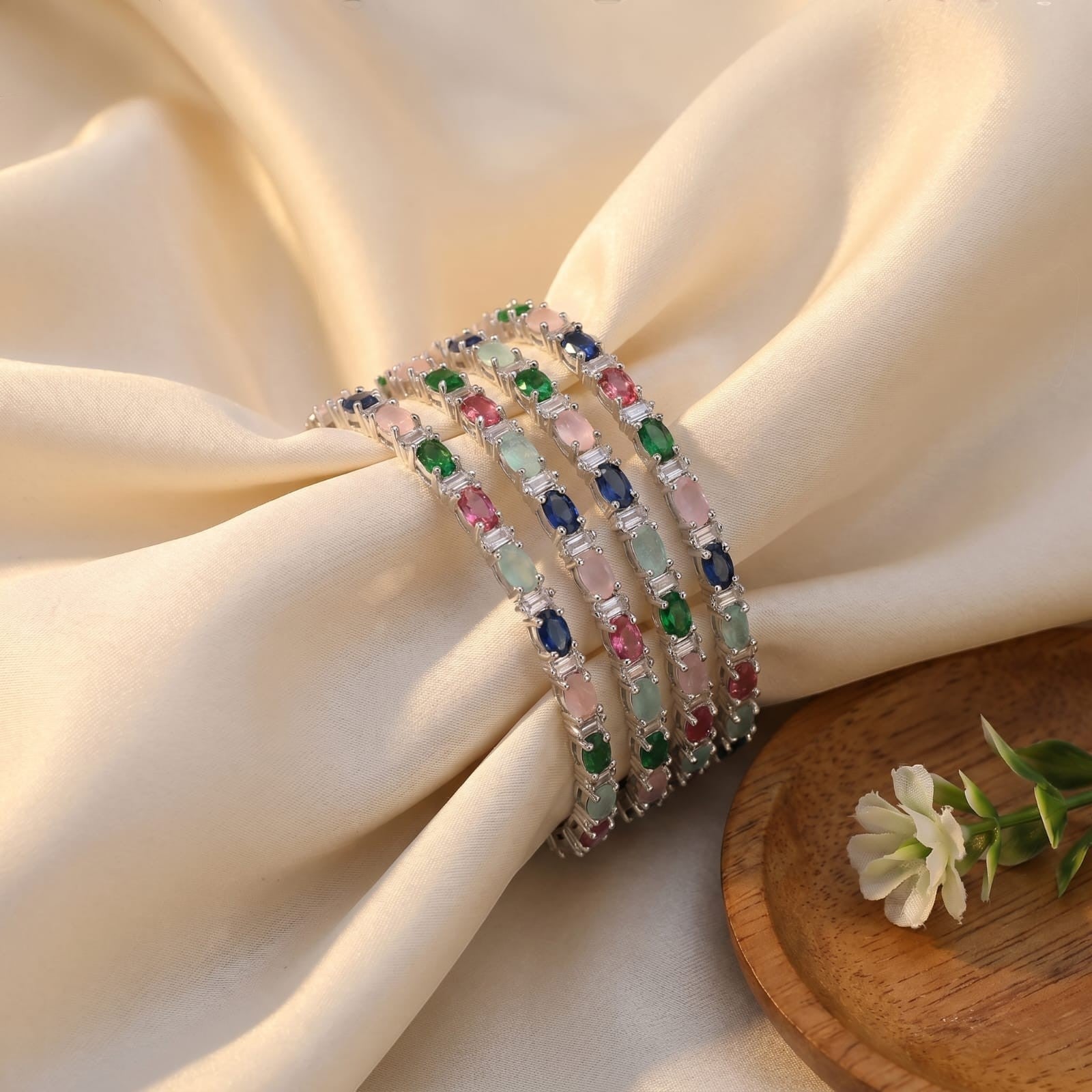 Shinayra by Nakhrali Creation Multicolour Oval CZ Bangle Set with green, blue, pink, aqua, and red stones and white CZ accents.