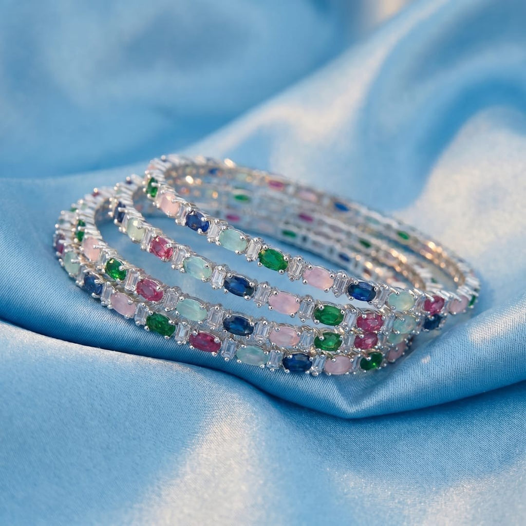 Shinayra by Nakhrali Creation Multicolour Oval CZ Bangle Set with green, blue, pink, aqua, and red stones and white CZ accents.