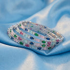 Shinayra by Nakhrali Creation Multicolour Oval CZ Bangle Set with green, blue, pink, aqua, and red stones and white CZ accents.