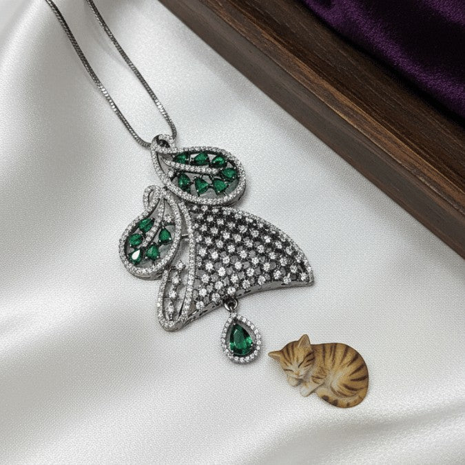 Shinayra by Nakhrali Creation oxidised silver pendant set with emerald green CZ stones and white CZ pave, leaf design with teardrop pendant.