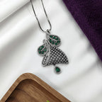 Shinayra by Nakhrali Creation oxidised silver pendant set with emerald green CZ stones and white CZ pave detailing. Leaf design with teardrop pendant.
