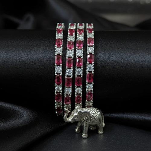 Shinayra by Nakhrali Creation set of 4 ruby red baguette and white round CZ tennis bangles with rhodium silver finish.
